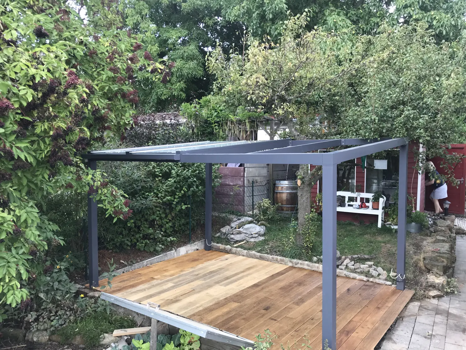 ein Gartenelement im Freien, das einen schattigen Gehweg, einen Durchgang oder einen Sitzbereich aus vertikalen Pfosten oder Säulen bildet, die normalerweise Querbalken und ein stabiles offenes Gitter tragen, auf dem häufig Gehölze gepflanzt werden.